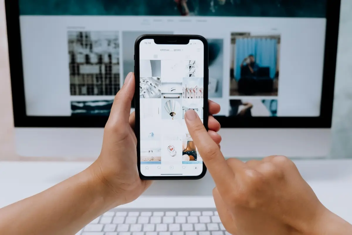 A person holding a smartphone looking at pictures in it
