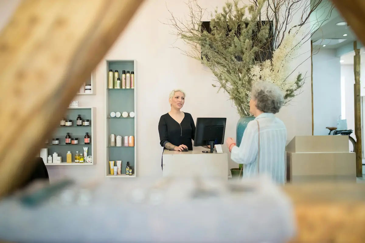 Recepcjonistka salonu fryzjerskiego rozmawiająca z klientką