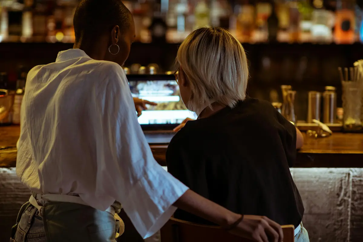 Dwie kobiety w restauracji rozmawiające przed laptopem