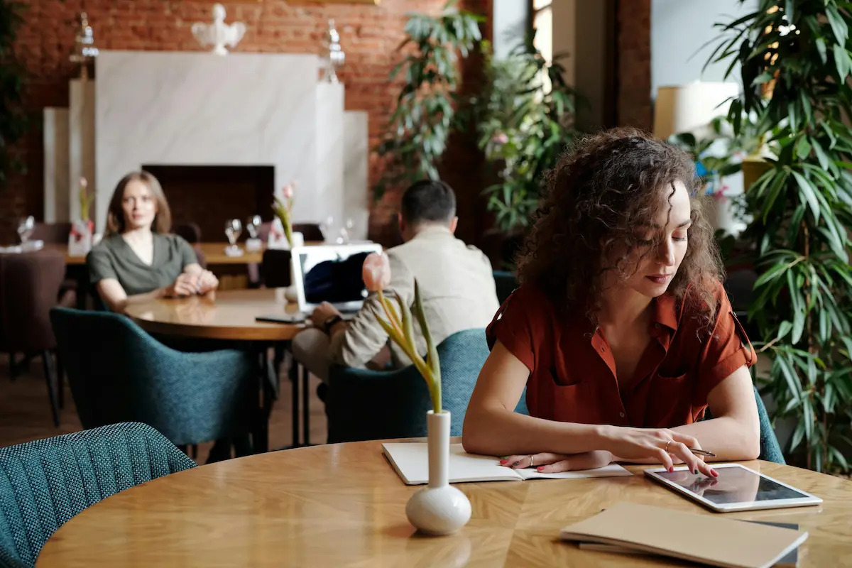 Kobieta siedząca w restauracji patrząca na tabletś