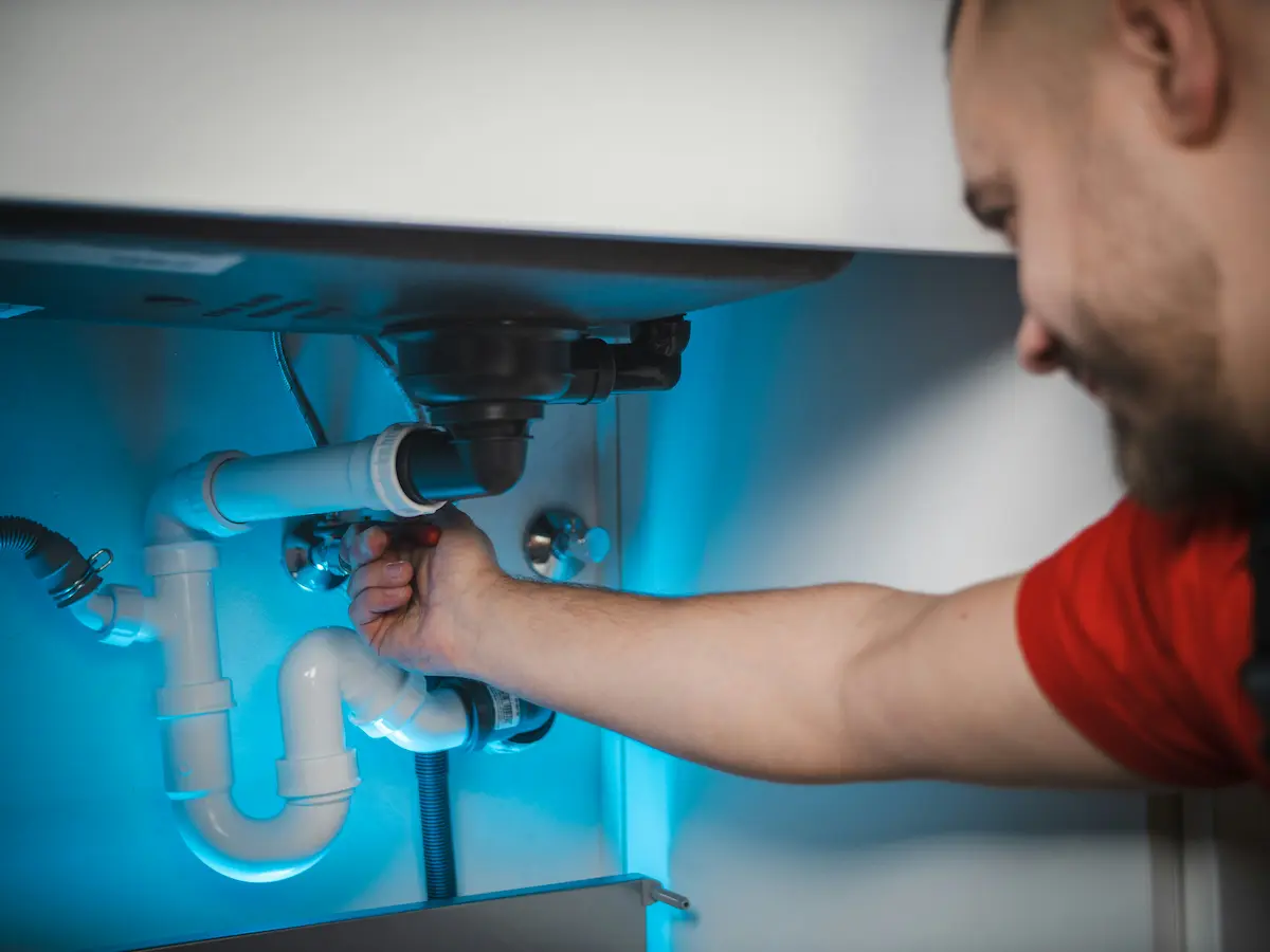 Widok laptopa z nowoczesną stroną internetową hydraulika, obok narzędzi instalacyjnych